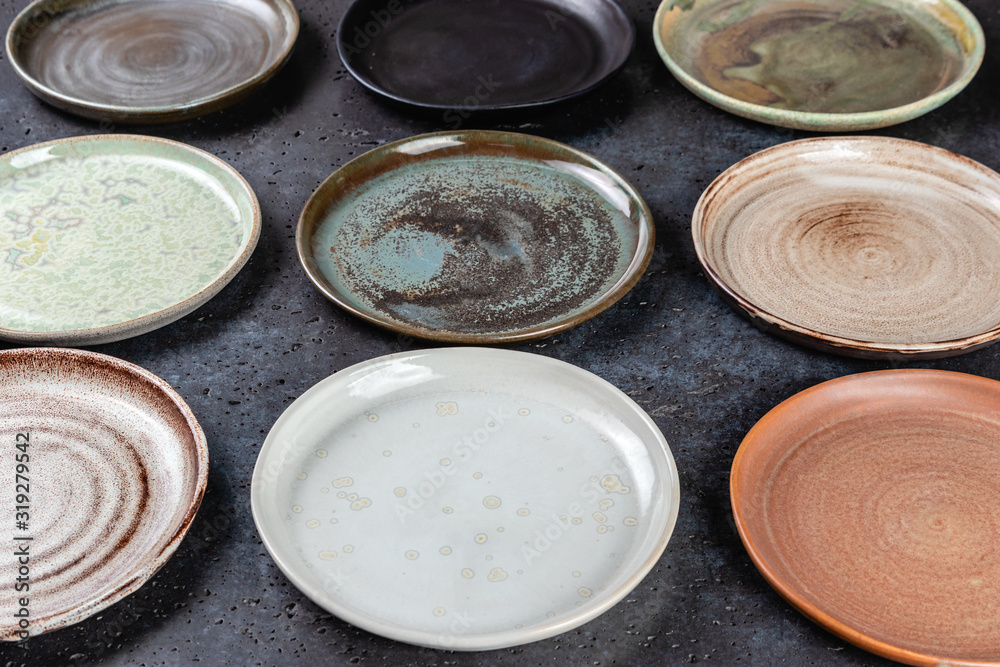 close-up abstract background made of decorative empty round ceramic dishes different colors, plates in the pottery workshop, handwork, top view close-up abstract background made of decorative empty round ceramic dishes different colors, plates in the pottery workshop, handwork, top view