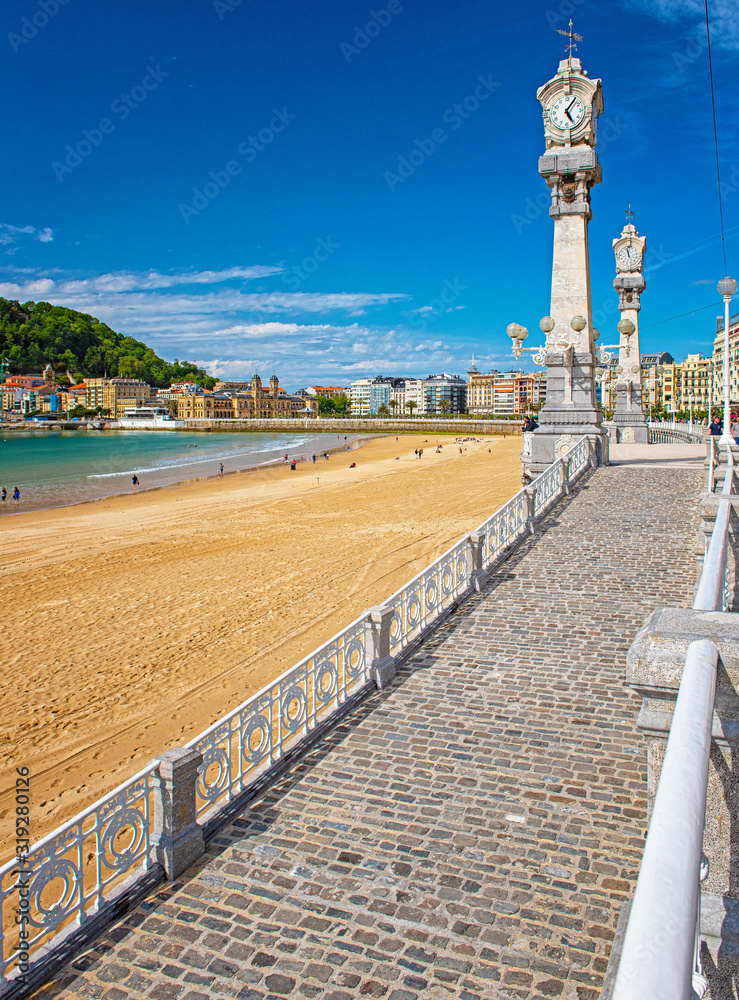 Obraz premium Ładna plaża ze starym miastem San Sebastian w Hiszpanii.