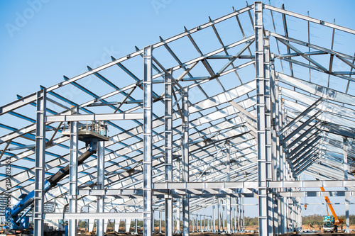 Steel frame workshop is under construction against a blue sky