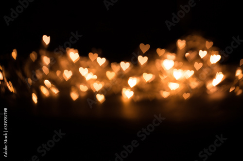 Blurred background, bokeh in the form of a heart of yellow warm color.