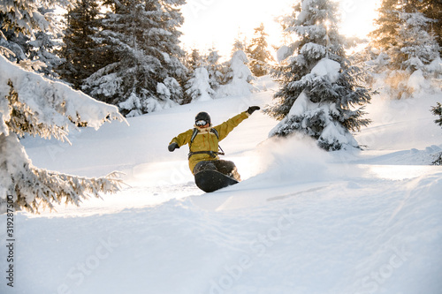 Male freeride snowboarder jumping the mountain snowcovered slope