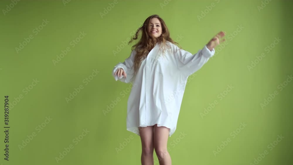 Girl With Long Hair Dancing On Background Of Light Green Wall. Girl With Long Hair Dancing On Background Of Light Green Wall.