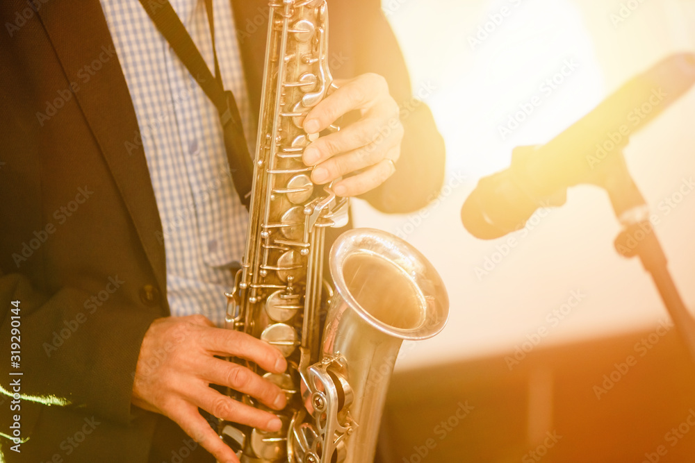 Obraz premium Jazz man musician playing saxophone with sun light