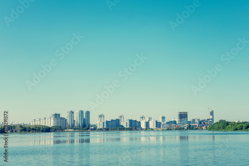 Summer morning in the city  apartment buildings  blue sky with clouds  Komsomol lake  Minsk  copy space  toned