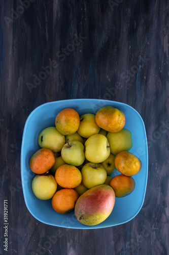 Mandarin Oranges  Apple and Mango Fresh Fruit on Blue Tray.