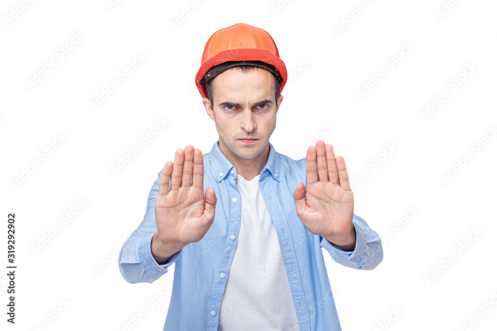 Builder in helmet shows gesture stop, isolated background, copy space Builder in helmet shows gesture stop, isolated background, copy space