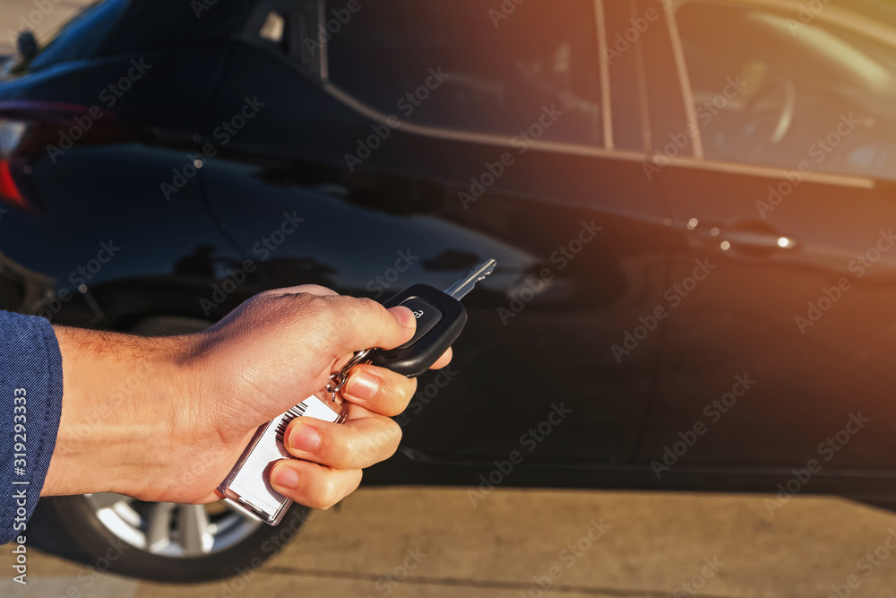 Man's hand pushing button on remote control car key