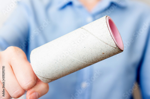 Person shows one-time paper roller with adhered dust, close up