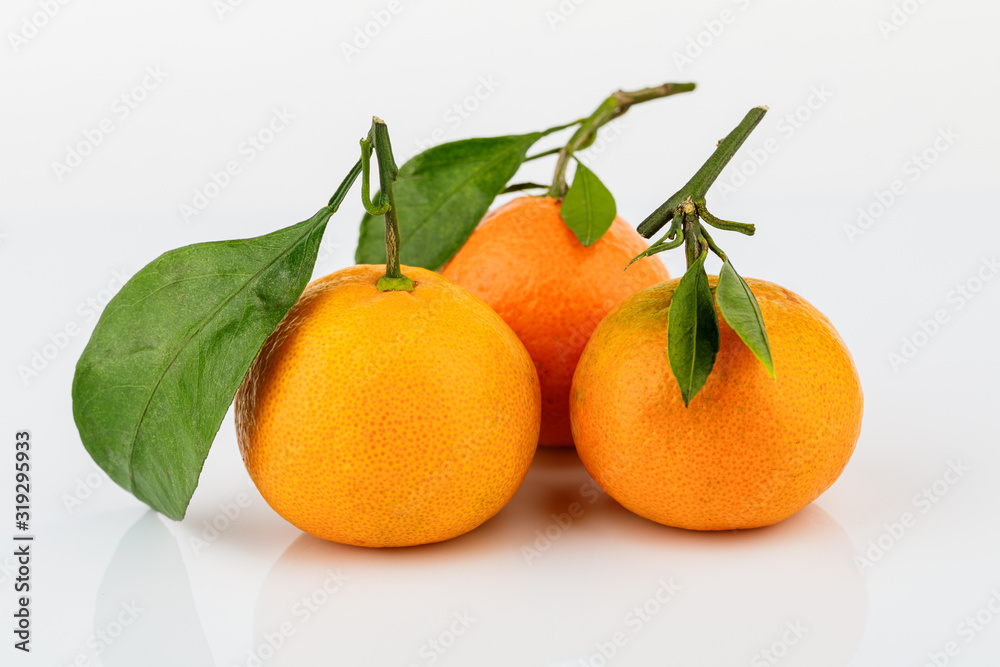 Ripe Mandarin with leaf close-up on white background Ripe Mandarin with leaf close-up on white background