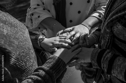 united hands of caucasian women in black and white, concept of motivation and teamwork © josecarlos