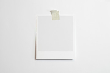 Blank polaroid photo frame with soft shadows and scotch tape isolated on white paper background as template for graphic designers presentations, portfolios etc.