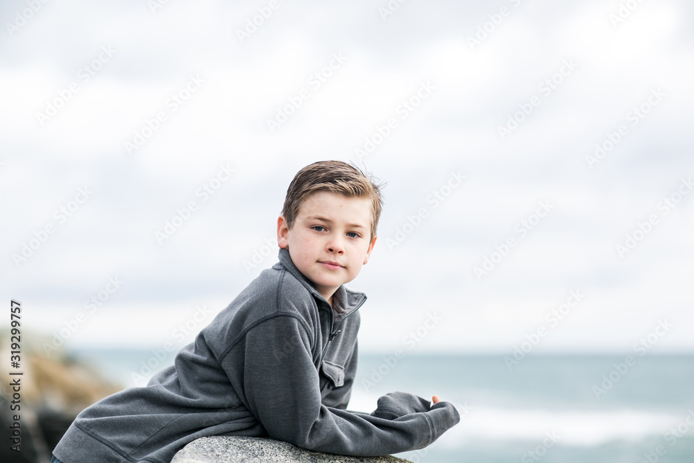 Thoughtful young boy on the beach looking