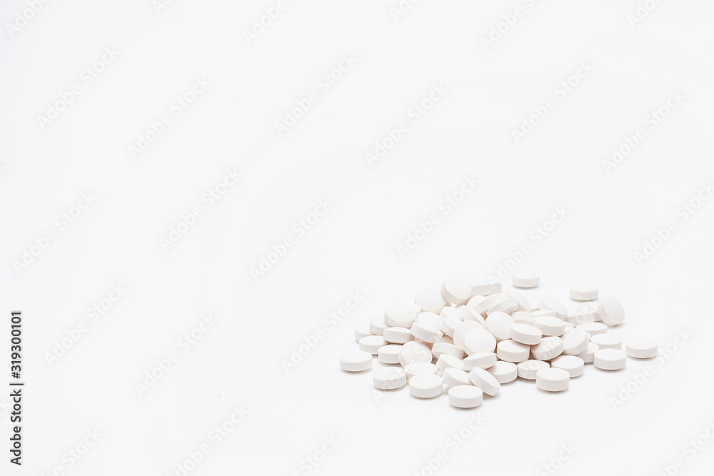 A handful of white tablets isolated on a white background, with copy space. The concept of the medicines and pills.
