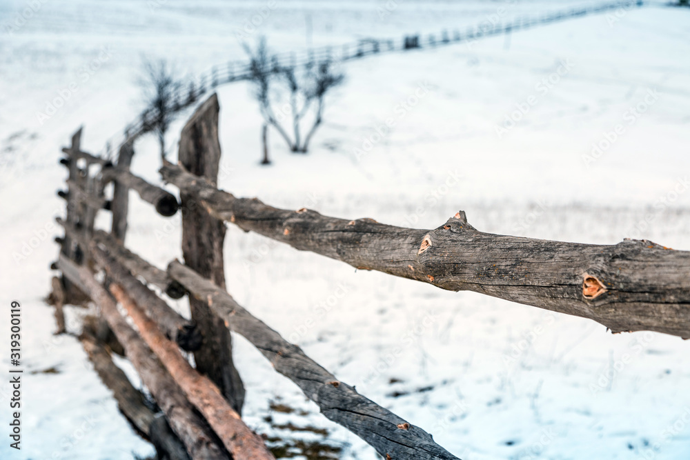 Fence of poles. Close up. Selective focus. Against the backdrop of winter landscape.