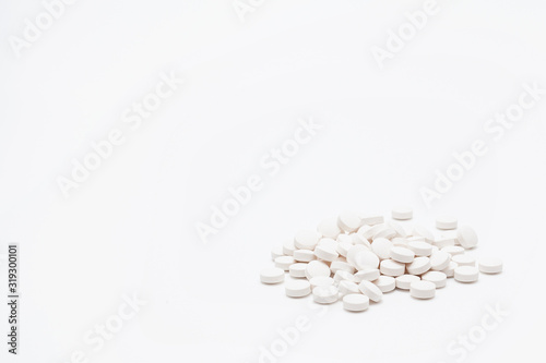 A handful of white tablets isolated on a white background, with copy space. The concept of the medicines and pills.