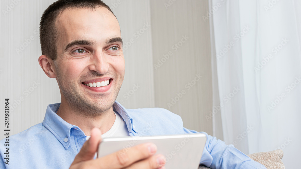Attractive man with phone, sitting at his home, portrait, toned, 16:9 Attractive man with phone, sitting at his home, portrait, toned, 16:9