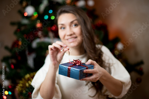 young woman opens a christmas present