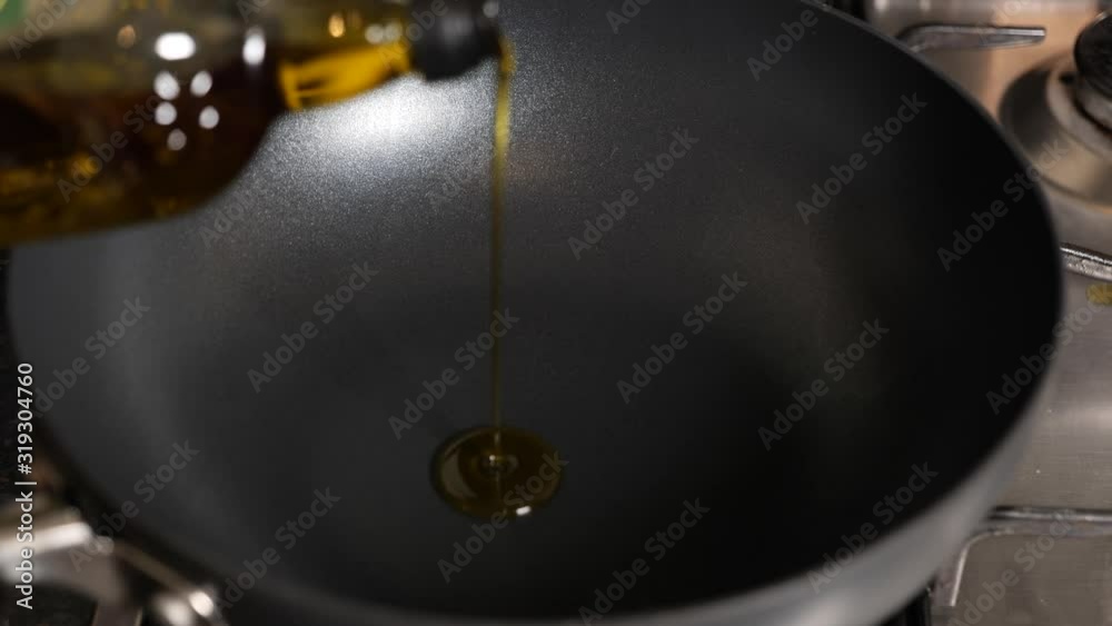 Pouring olive oil into a frying pan close-up