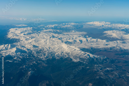 Winter mountains from the plane window. Turkish mountains landscape aerial view. Snow peaks. © garrykillian