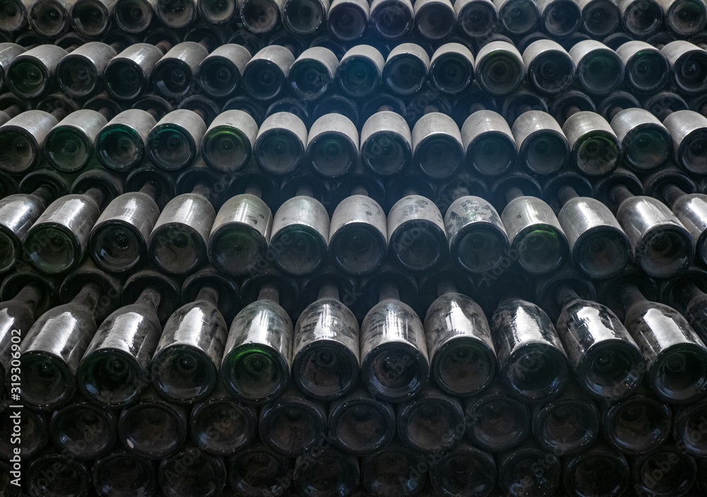 Dusty old wine bottles stacked together in a wine cellar Dusty old wine bottles stacked together in a wine cellar