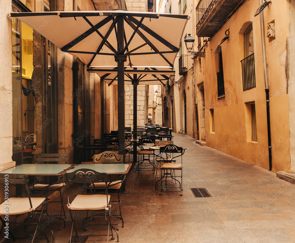 Small street passage with few empty cafes