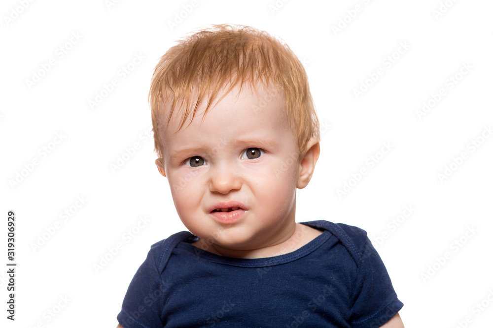small child with a displeased face looks into the frame, toddler isolated on a white background. small child with a displeased face looks into the frame, toddler isolated on a white background.