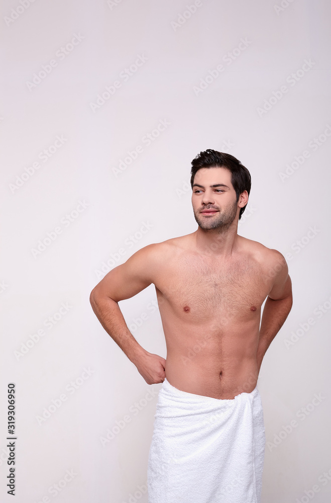 Young caucasian man shirtless wearing a towel.
