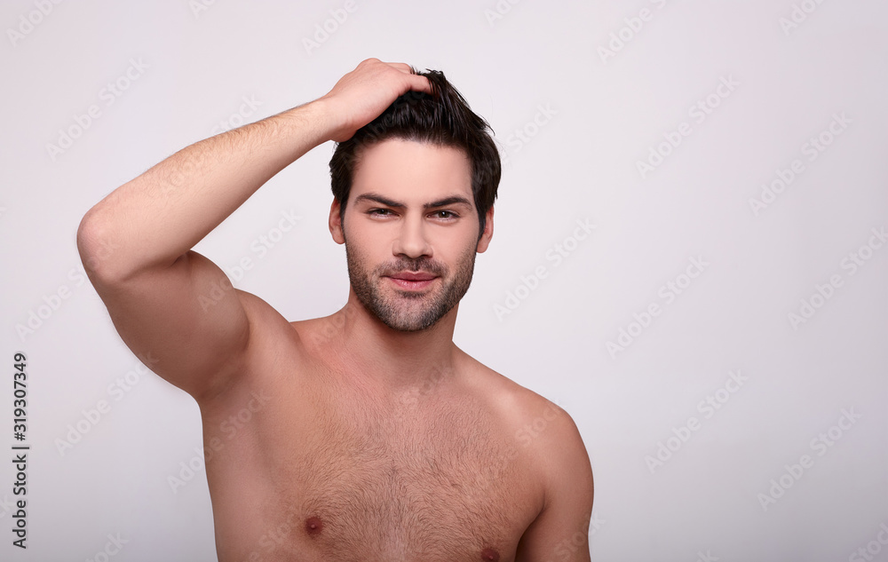 Brutal male looking directly at the camera with a hand on his hair Brutal male looking directly at the camera with a hand on his hair
