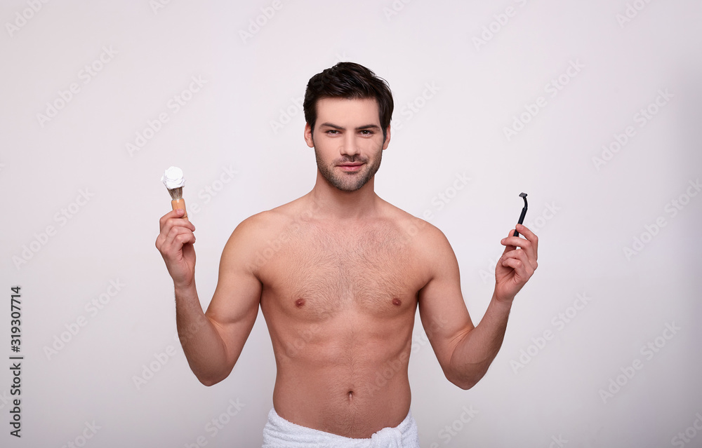 Portrait of pretty boy with little brush and razor for shaving