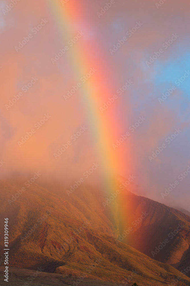 Fiery rainbow at sunset over the west maui mountains.