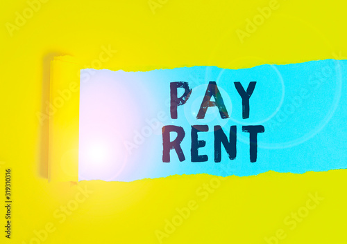 Writing note showing Pay Rent. Business concept for To pay money in exchange for the use of someone else s is property Cardboard which is torn placed above a wooden classic table photo