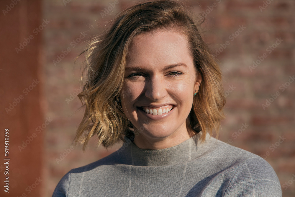 caucasian millennial female business owner on brick wall in grey turtleneck in brooklyn caucasian millennial female business owner on brick wall in grey turtleneck in brooklyn