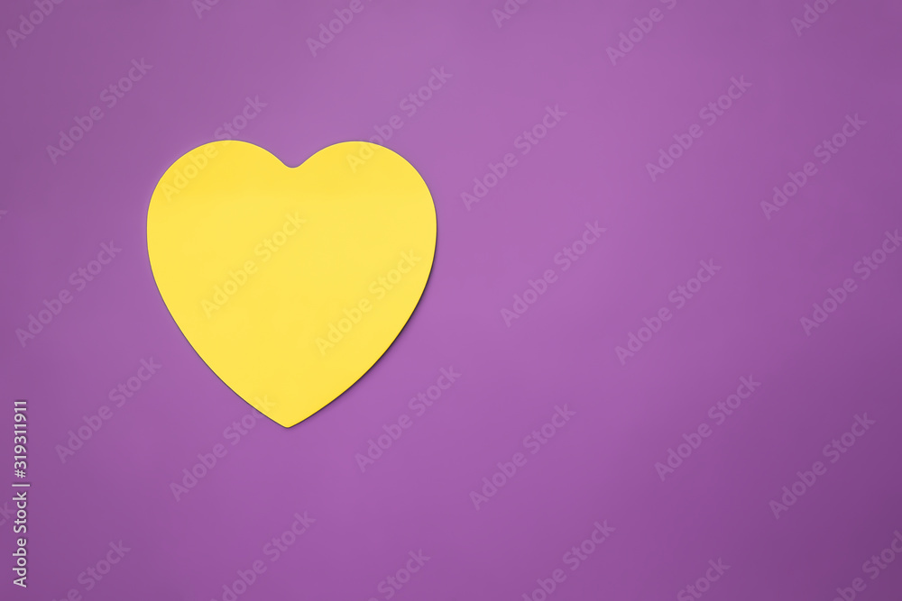 Composition with yellow heart on a purple background with copy space