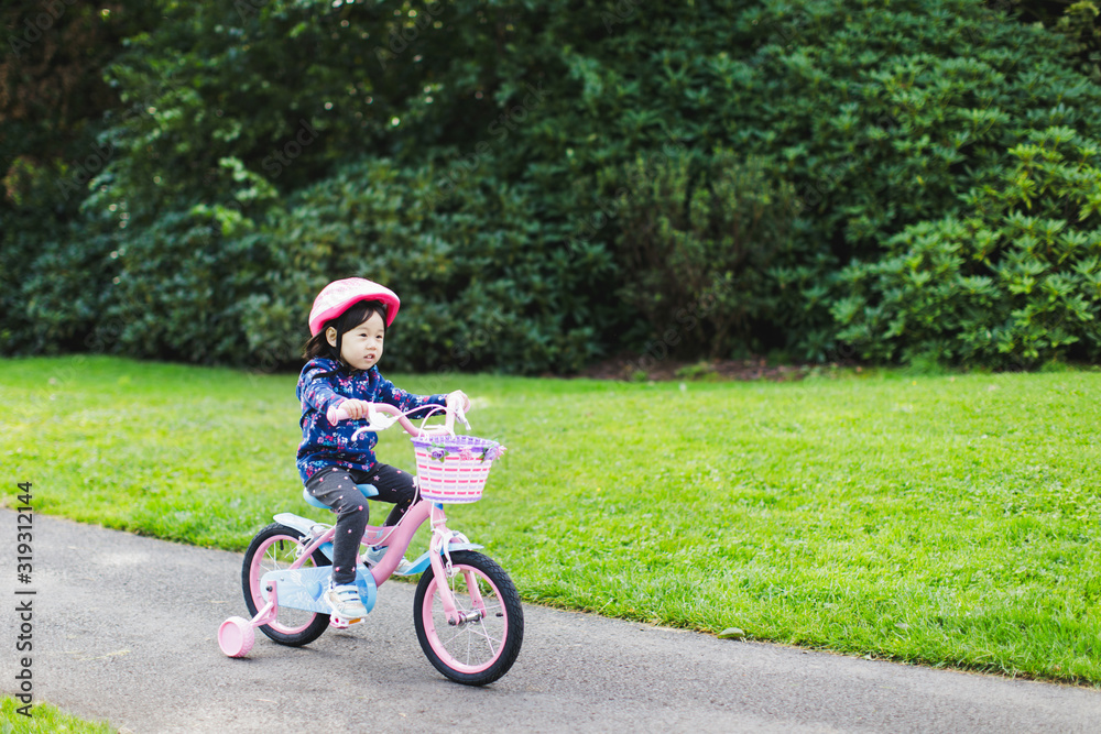 toddler girl riding bicycle in spring countryside park,Northern Ireland toddler girl riding bicycle in spring countryside park,Northern Ireland