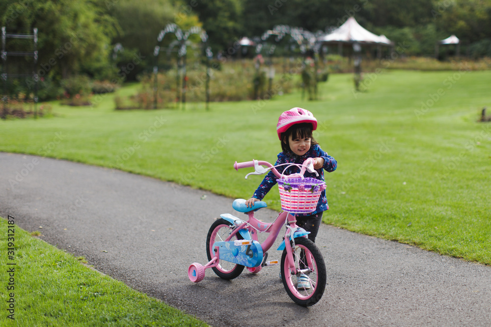 toddler girl riding bicycle in spring countryside park,Northern Ireland toddler girl riding bicycle in spring countryside park,Northern Ireland