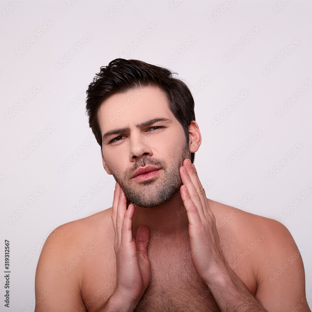 Fototapeta premium Brutal unshaven guy touches his stubble