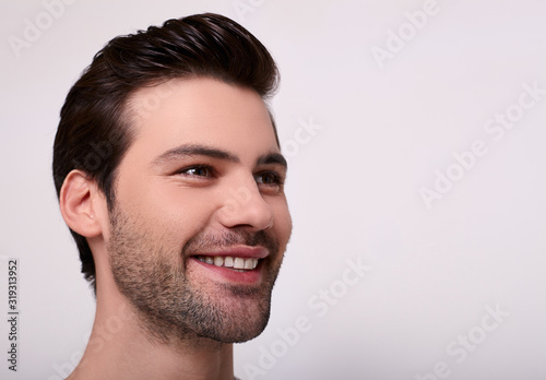 A close-up, a portrait of a smiling happy young Caucasian.