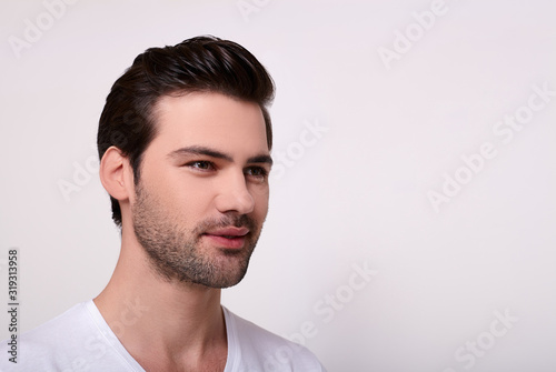 Portrait of a smiling handsome man in a white T-shirt.