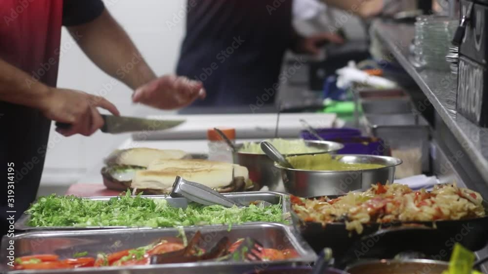 man makes Milanese sandwich at a local food, typical Argentine food man makes Milanese sandwich at a local food, typical Argentine food