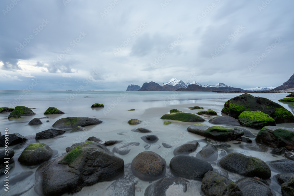 Wet boulders and rocks in Lofoten islands during sunset and blue hours in spring. Long exposure photography. Traveling and explorer concept.
