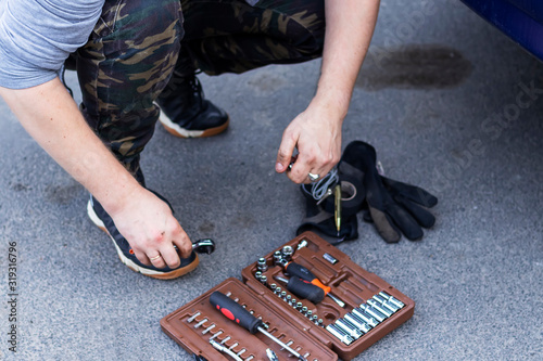 White man takes tools from a suitcase for car repair photo