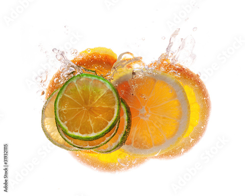 Fototapeta Naklejka Na Ścianę i Meble -  Beautiful bright glowing slices of citrus in a spray of water isolated on white background