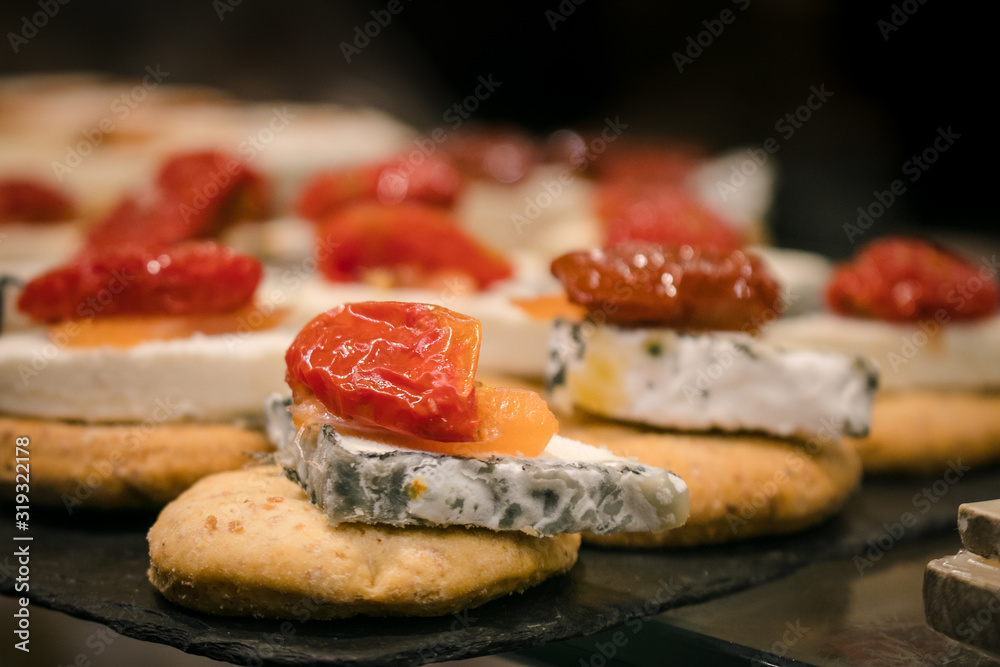 Blue cheese with dry tomato pintxos or tapas, spanish canapes, in San Miguel Market Madrid 