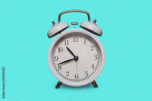 Fototapeta Naklejka Na Ścianę i Meble -  Old fashioned white alarm clock on aquamarine background