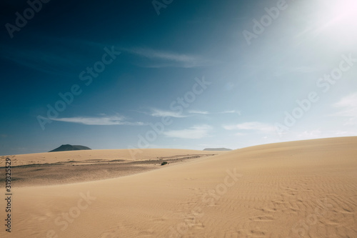 Sand desert dunes landscape with blue sky in background - concept of climate change and arid future on the planet earth - enviroment and outdoor nature scenic place