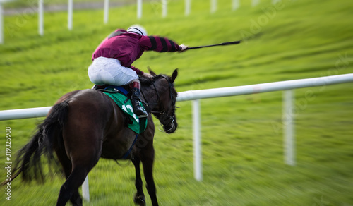 fast blurry motion of galloping race horse and jockey holding whip, fast action motion blur effect