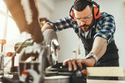 young male carpenter working in  workshop