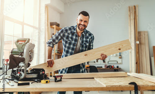 Fotografija young male carpenter working in  workshop