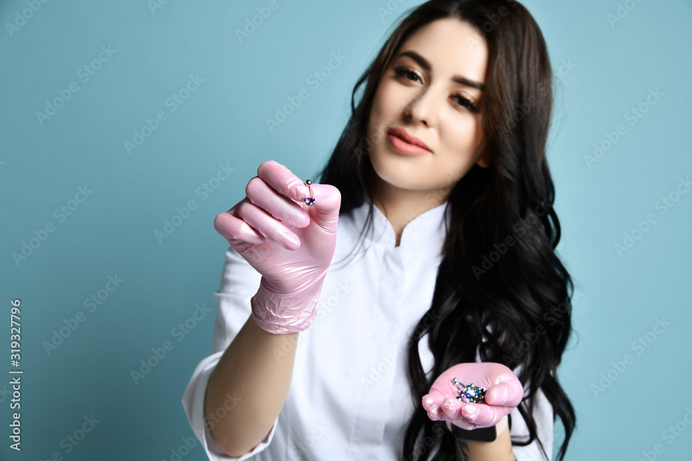 Portrait of young beautiful sexy brunette woman doctor or nurse in white costume and pink gloves holding accessories Portrait of young beautiful sexy brunette woman doctor or nurse in white costume and pink gloves holding accessories