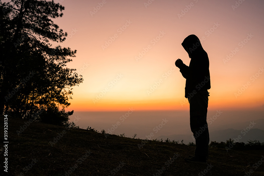 Silhouette of christian man hand praying